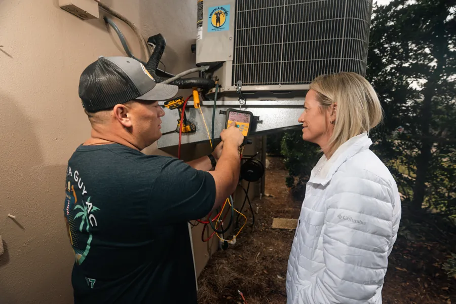 Technician walking a homeowner through the outdoor unit