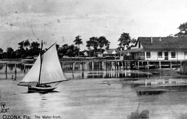 Historic photo of the Ozona waterfront with a sailboat and pier