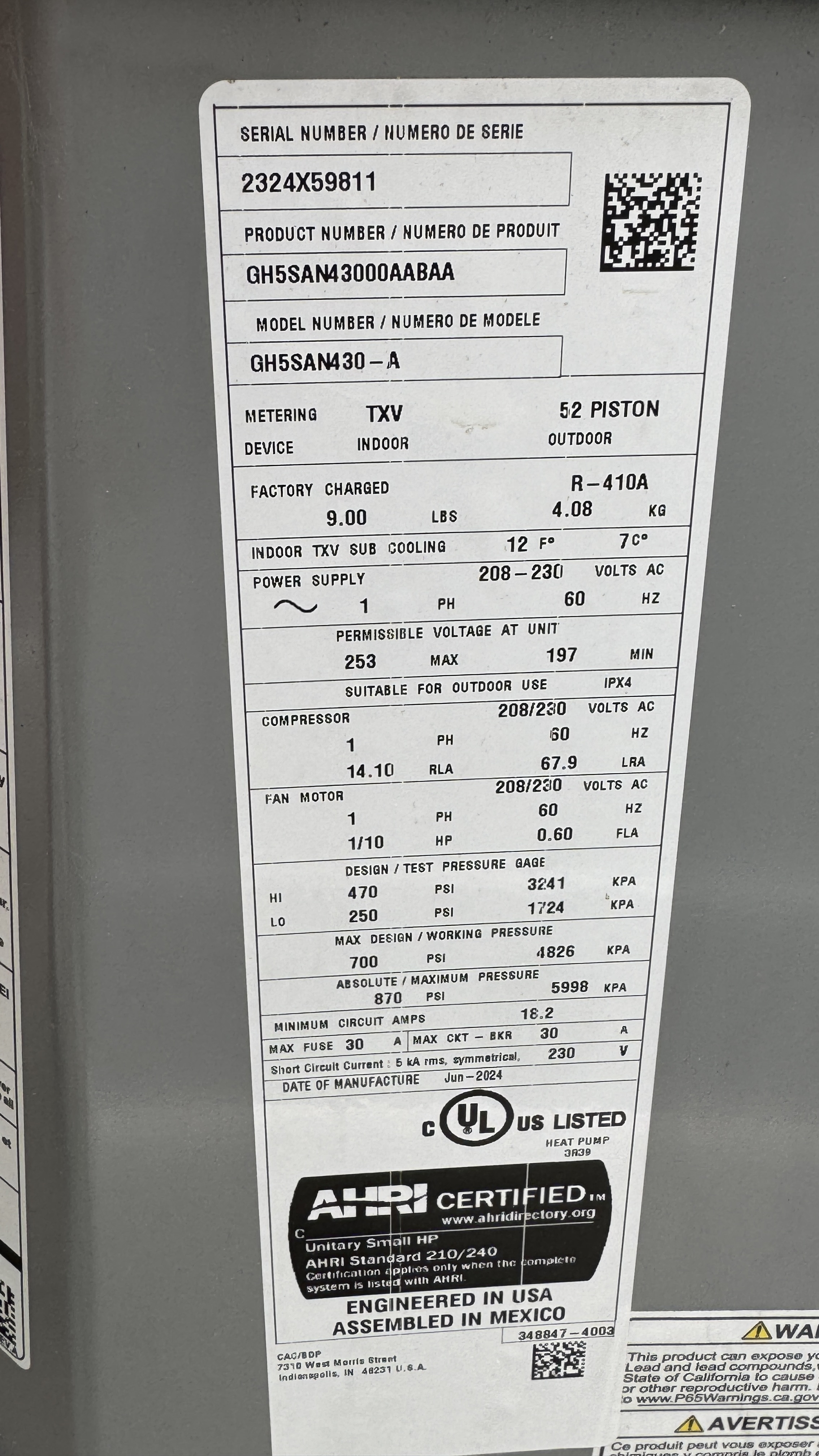The metal data plate on an outdoor AC condenser — the label the price tool reads