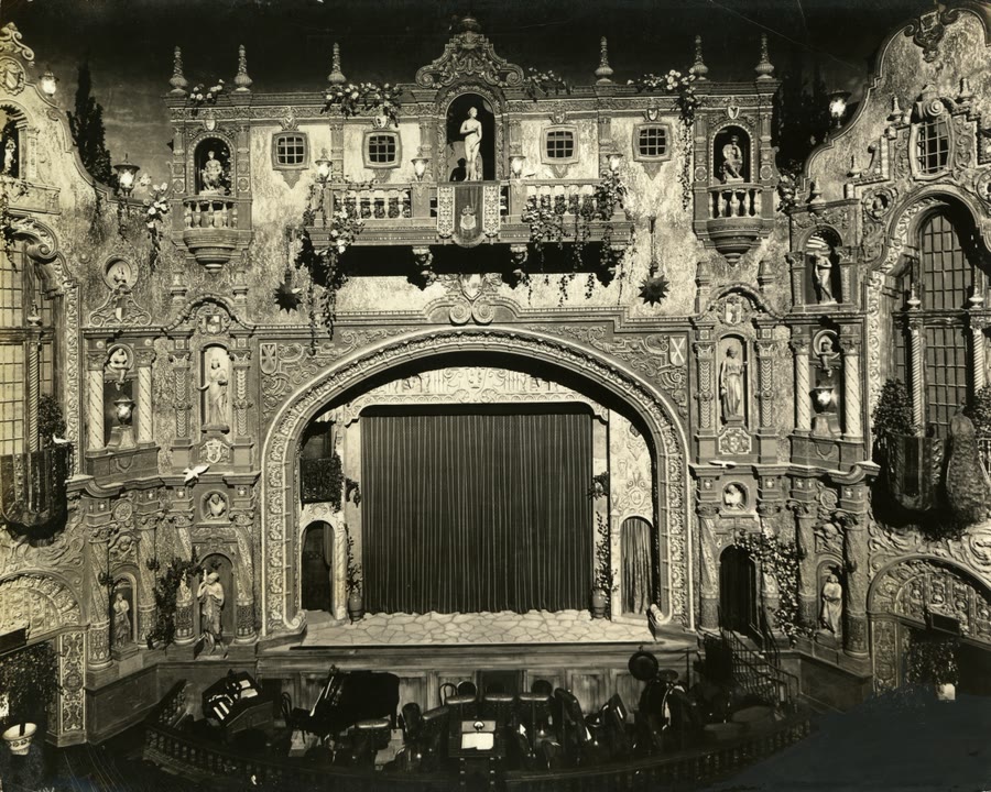 The ornate Mediterranean Revival interior of the Tampa Theatre, with balconies, statues, and an atmospheric ceiling.