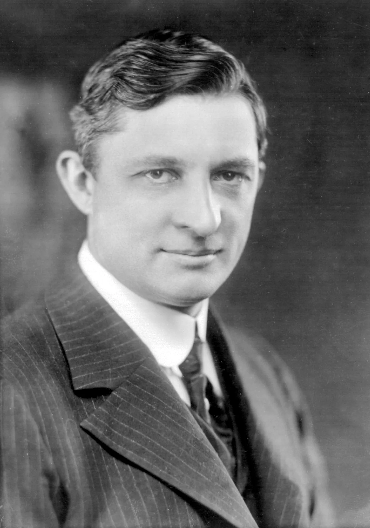 Formal portrait of an engineer in a suit and round glasses, about 1915.